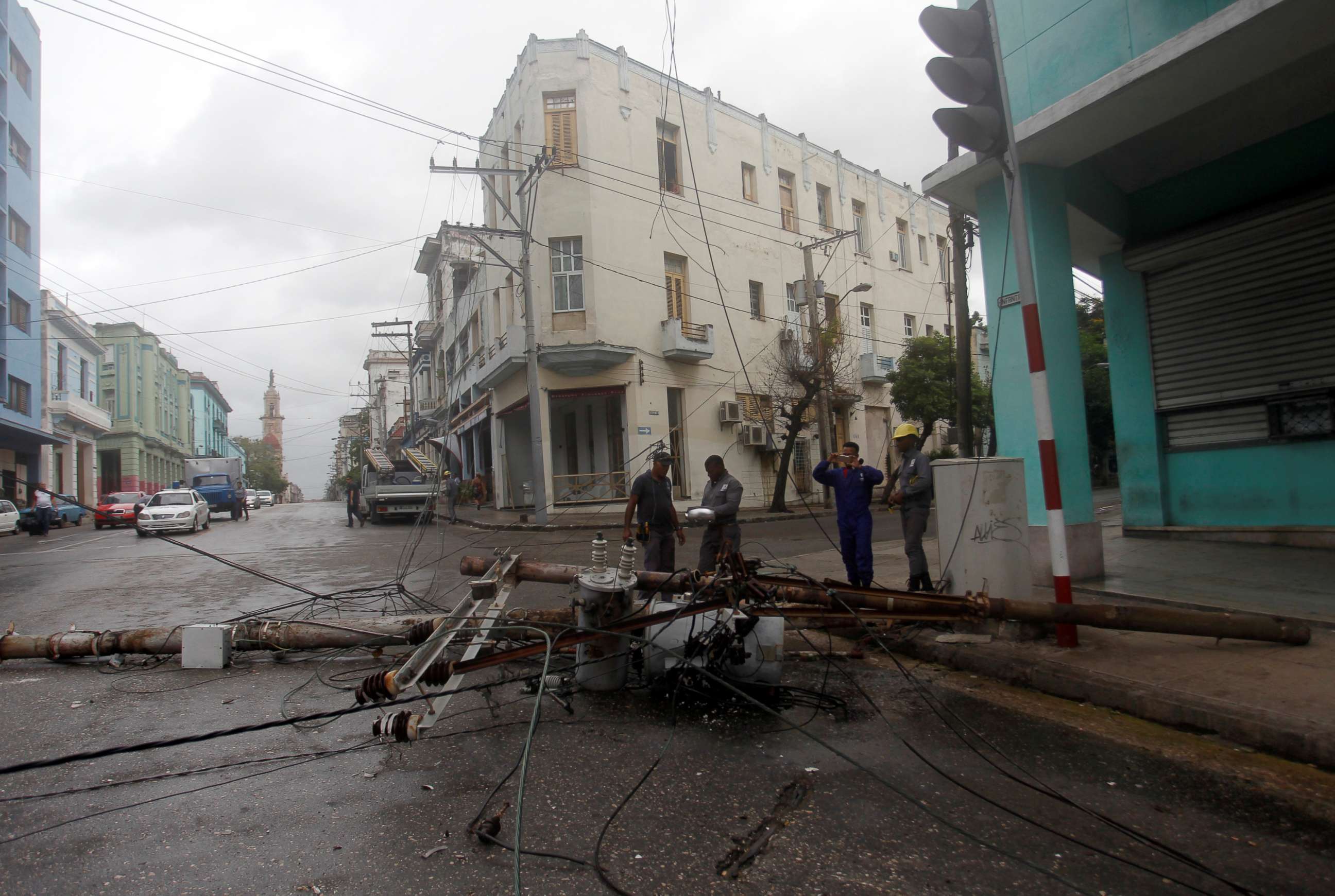 PHOTO: Workers stand near an electricity pole that was knocked down by heavy winds, ahead of the passing of Hurricane Irma, in Havana, Cuba, Sept. 9, 2017. 