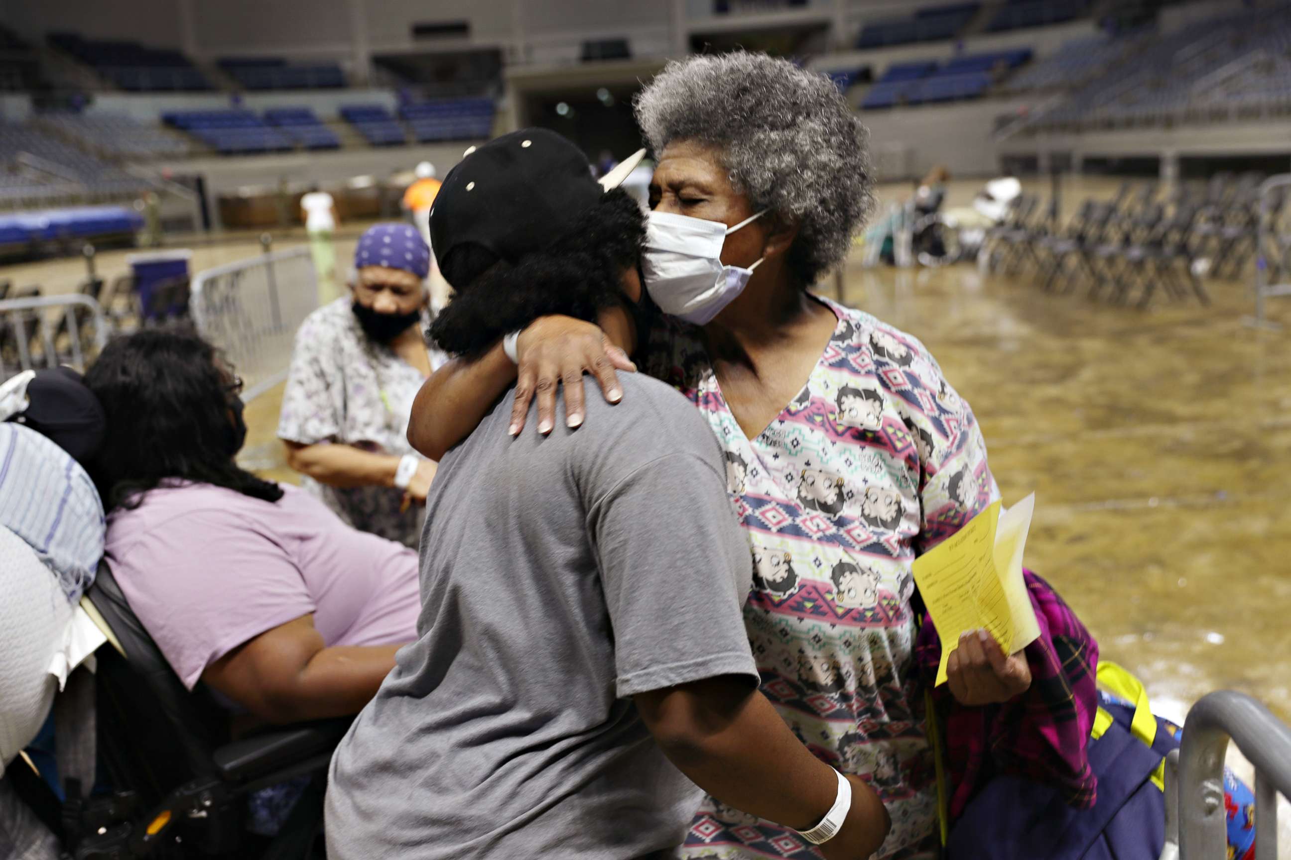 PHOTO: Demeteri Bushnell gets a hug from her great niece as they and other evacuees prepare to board a bus as they are evacuated by local and state government officials before the arrival of Hurricane Laura, on Aug. 26, 2020, in Lake Charles, Louisiana.