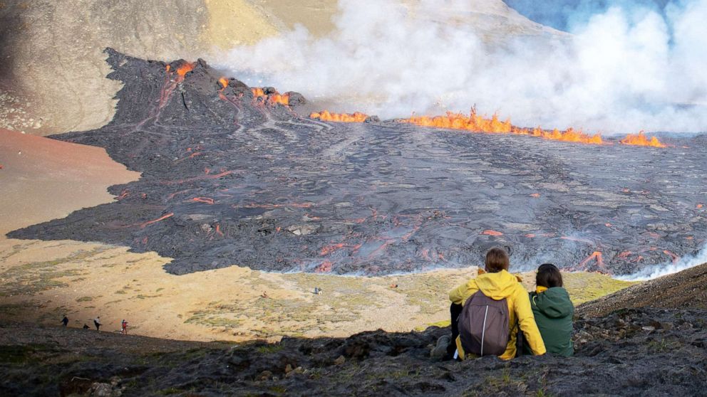 PHOTO: People look at the lava flowing at the scene of the newly erupted volcano at Grindavik, Iceland on Aug. 3, 2022.