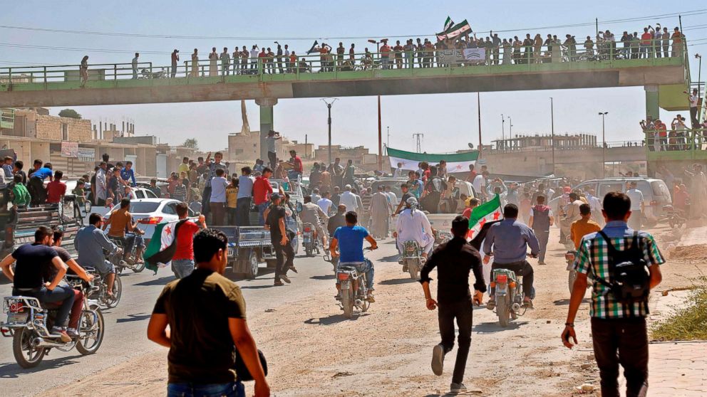 Syrians chant slogans and wave flags of the opposition as they protest against the regime and its ally Russia, in the rebel-held town of Maarrat al-Numan in the north of Idlib province on Aug. 31, 2018.