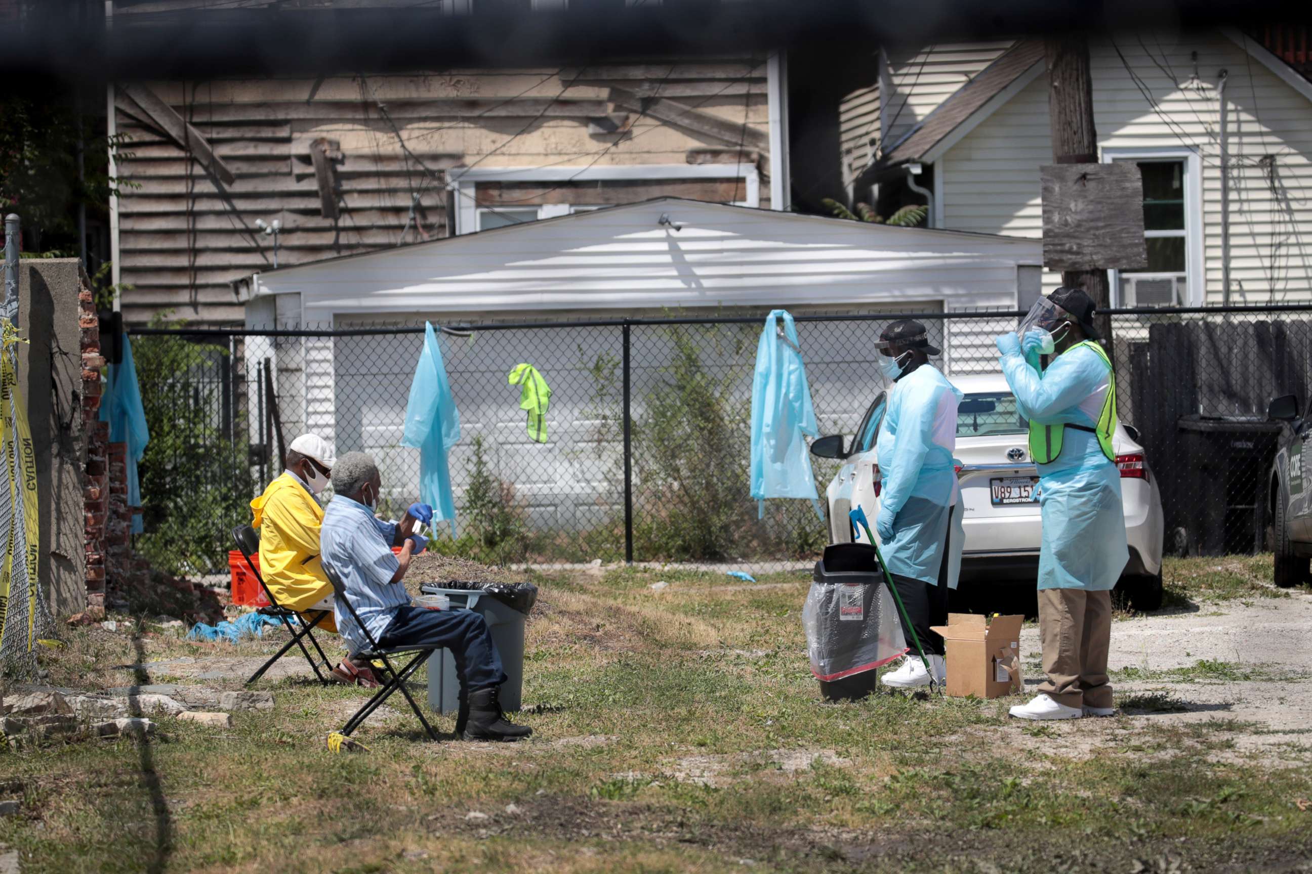 PHOTO: Workers talk residents through a COVID-19 self-test at a mobile COVID-19 testing site set up on a vacant lot in the Austin neighborhood on June 23, 2020 in Chicago.