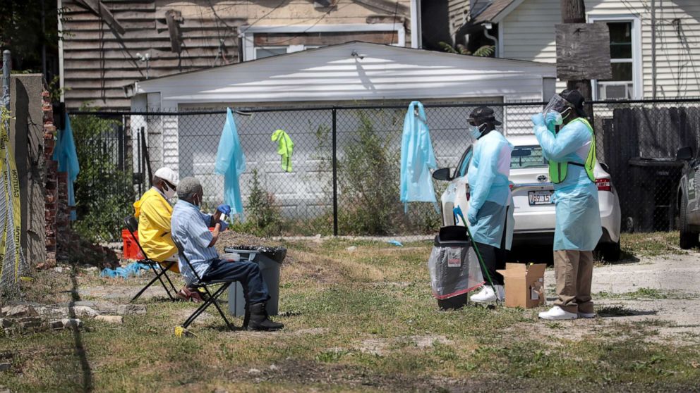 PHOTO: Workers talk residents through a COVID-19 self-test at a mobile COVID-19 testing site set up on a vacant lot in the Austin neighborhood on June 23, 2020 in Chicago.