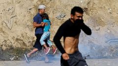 PHOTO: Migrants, part of a caravan of thousands traveling from Central America en route to the United States, run from tear gas released by U.S. border patrol near the fence between Mexico and the United States in Tijuana, Mexico, Nov. 25, 2018.