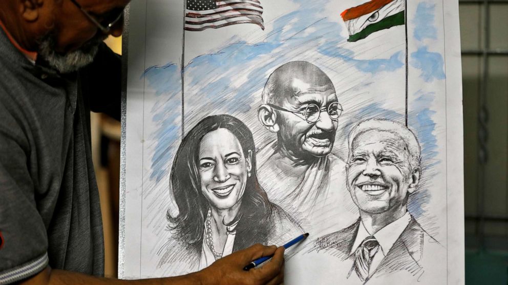 PHOTO: Aejaz Saiyad, an artist, gives finishing touches to a drawing of U.S. President-elect Joe Biden, Vice President-elect Kamala Harris and India's independence hero Mahatma Gandhi at his home in Ahmedabad, India, January 20, 2021. 