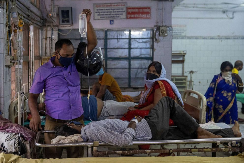 PHOTO: A man holds up an intravenous (IV) drip being used to treat his relative as they wait for him to be transferred to a hospital bed in the emergency ward of Jawahar Lal Nehru Medical College and Hospital,in Bhagalpur, Bihar, India, July 28, 2020. 