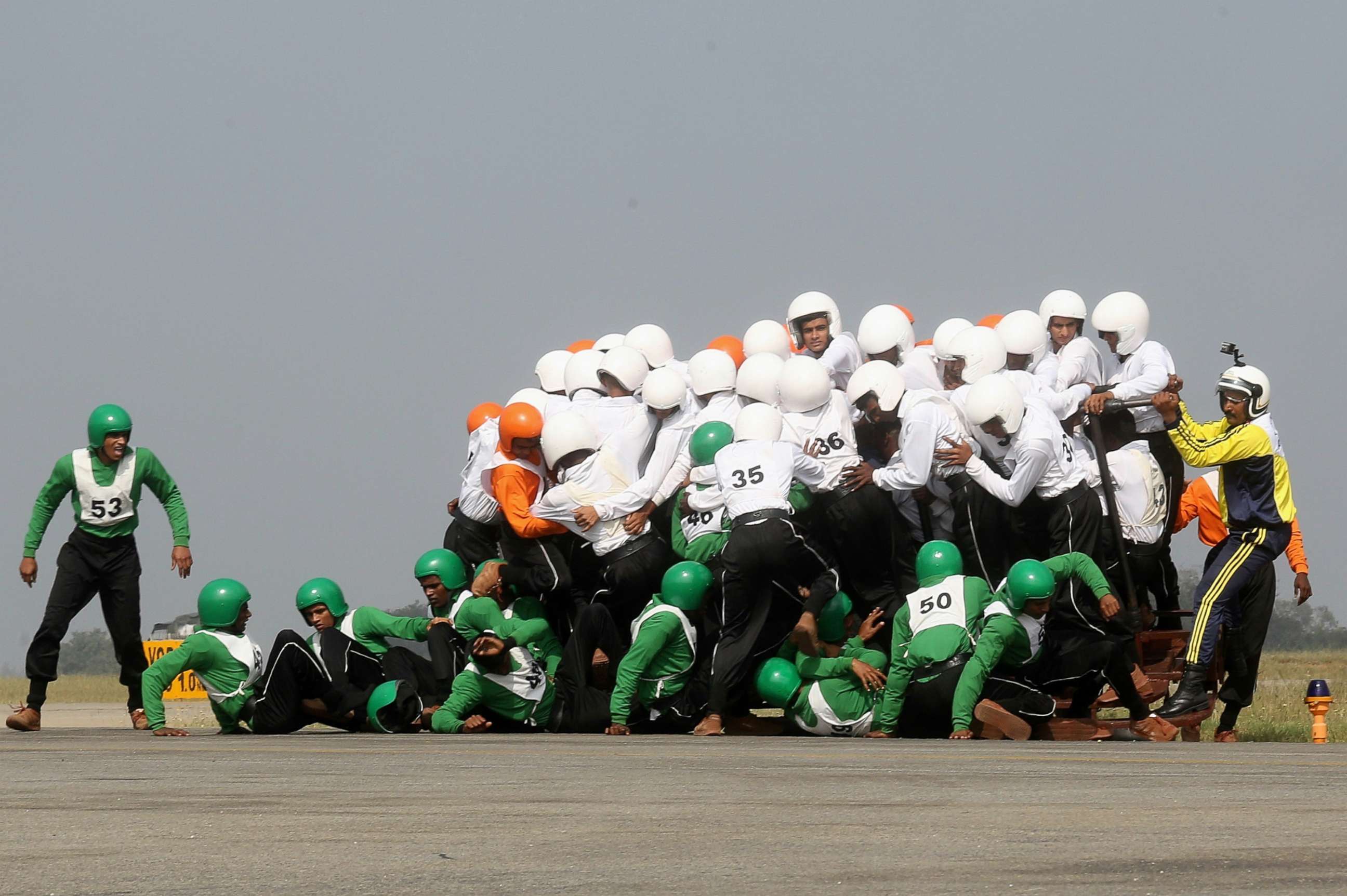 PHOTO: Members of the Army Service Corps motorcycle display team fall off and fail in a first attempt to break a World Record at the Air Force Station Yelahanka, in Bangalore, India, Nov. 19, 2017.