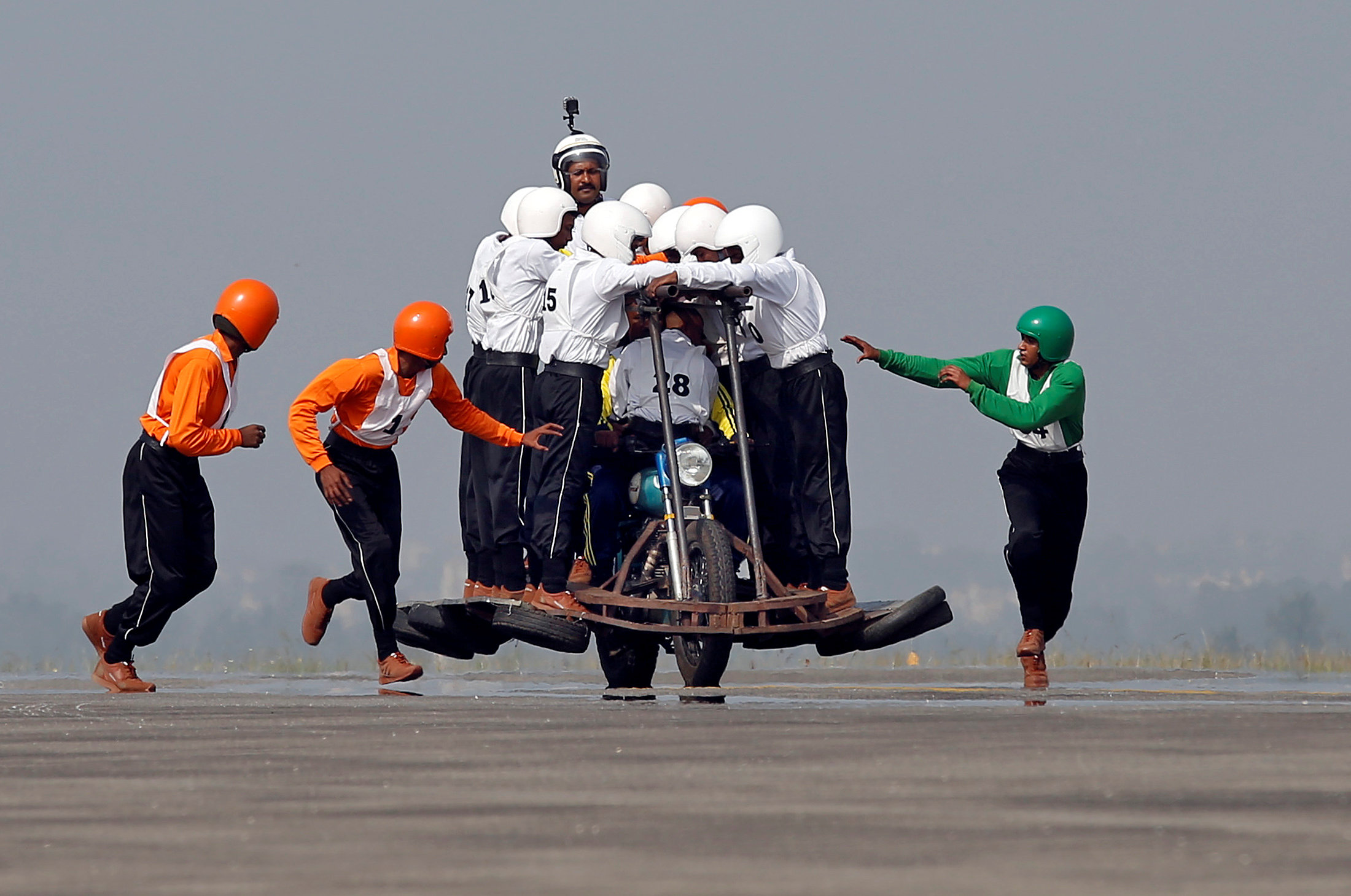 PHOTO: Members of Army Service Corps "Tornadoes" run to climb onto a motorcycle as they attempt to create a world record for most men on a single moving motorcycle at the Yelahanka Air Force Station in Bengaluru, India, Nov. 19, 2017.