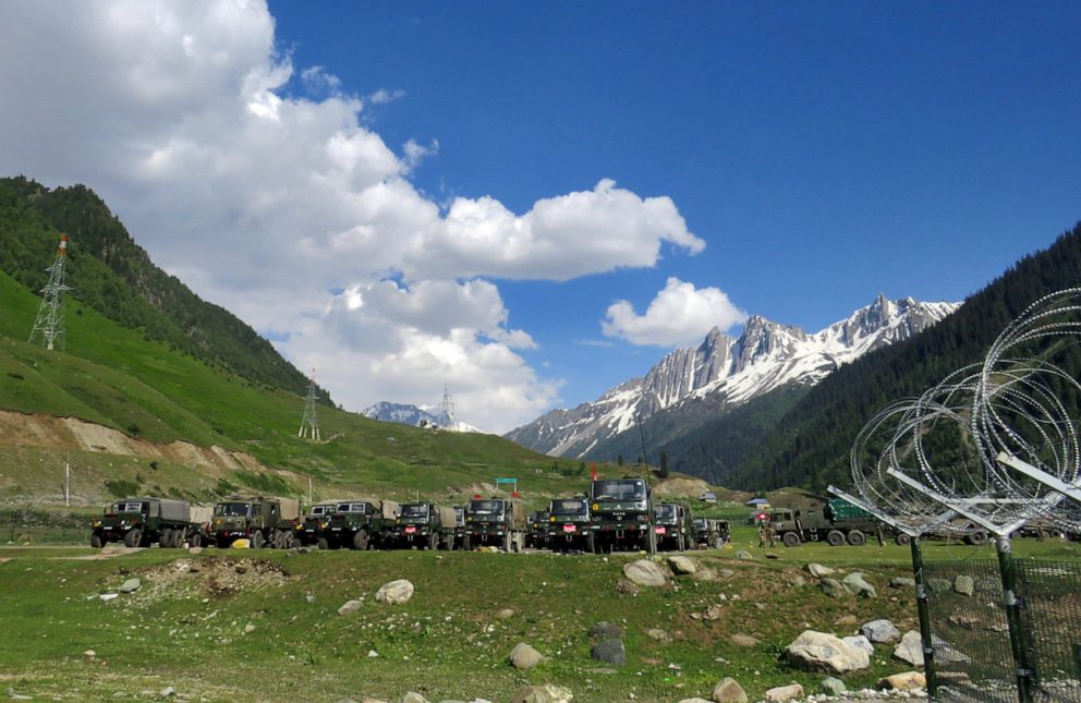 PHOTO: Army soldiers walk past their parked trucks at a makeshift transit camp before heading to Ladakh, near Baltal, southeast of Srinagar, India, June 16, 2020.