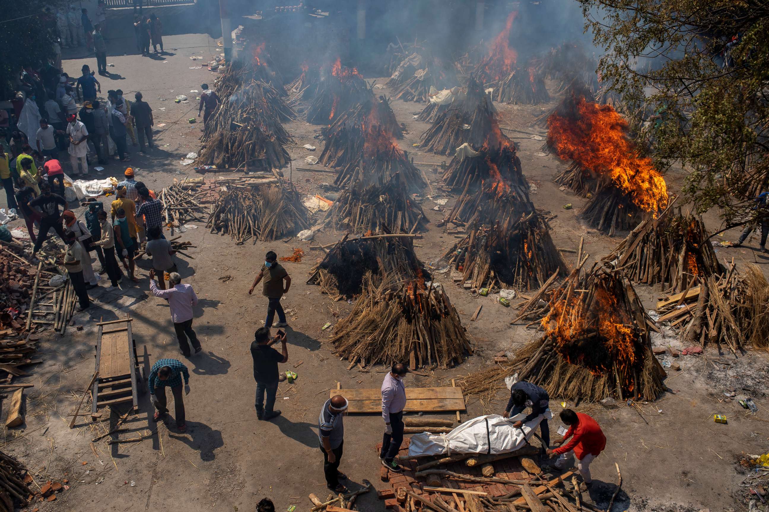 PHOTO: Multiple funeral pyres of victims of COVID-19 burn at a ground that has been converted into a crematorium for mass cremation in New Delhi, India, April 24, 2021.