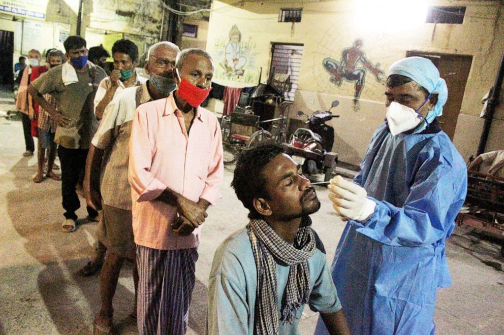 PHOTO: A health worker collects nasal swab samples from homeless people for corona virus Rapid Antigen Testing in New Delhi, India, Sept. 22, 2020.