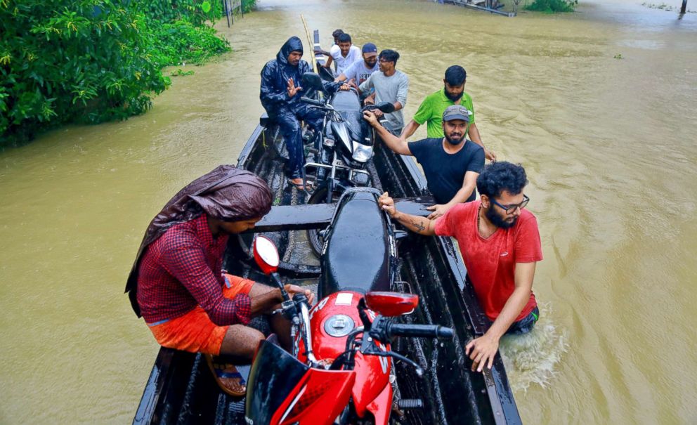 PHOTO: People salvage motorcycles in a country boat in a flooded area in Alappuzha, Kerala state, India, Aug. 17, 2018.