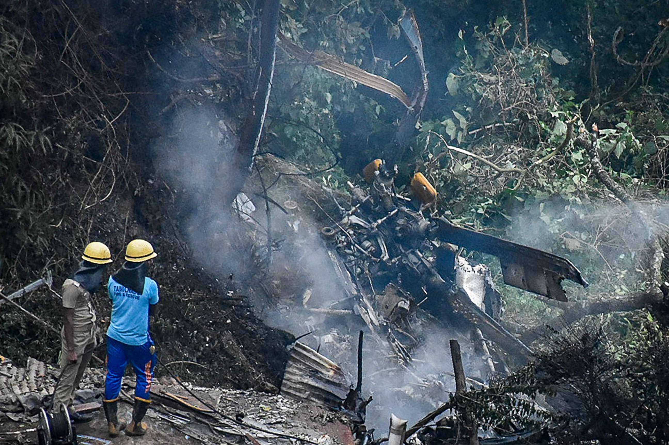 PHOTO: Firemen and rescue workers stand next to the debris of an IAF Mi-17V5 helicopter crash site in Coonoor, Tamil Nadu, on Dec. 8, 2021.