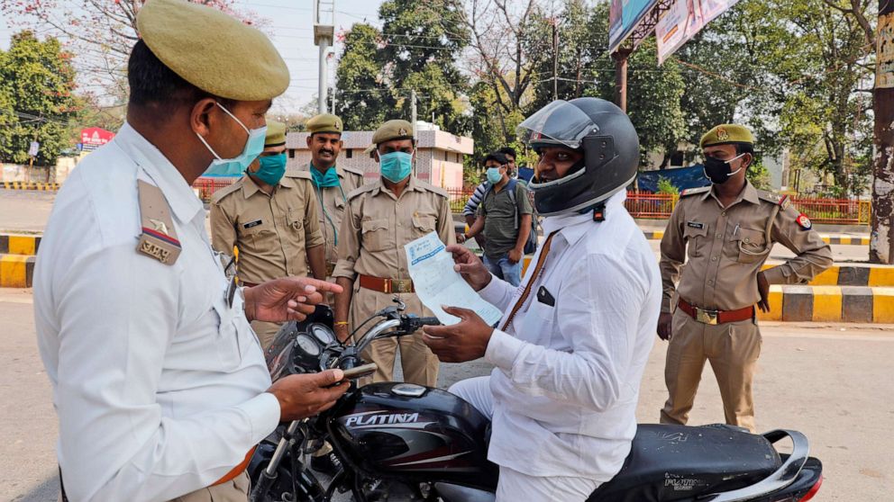 PHOTO: A commuter shows a doctor's prescription to policemen keeping guard during a complete lockdown amid growing concerns of coronavirus in Prayagraj, India, March 24, 2020.