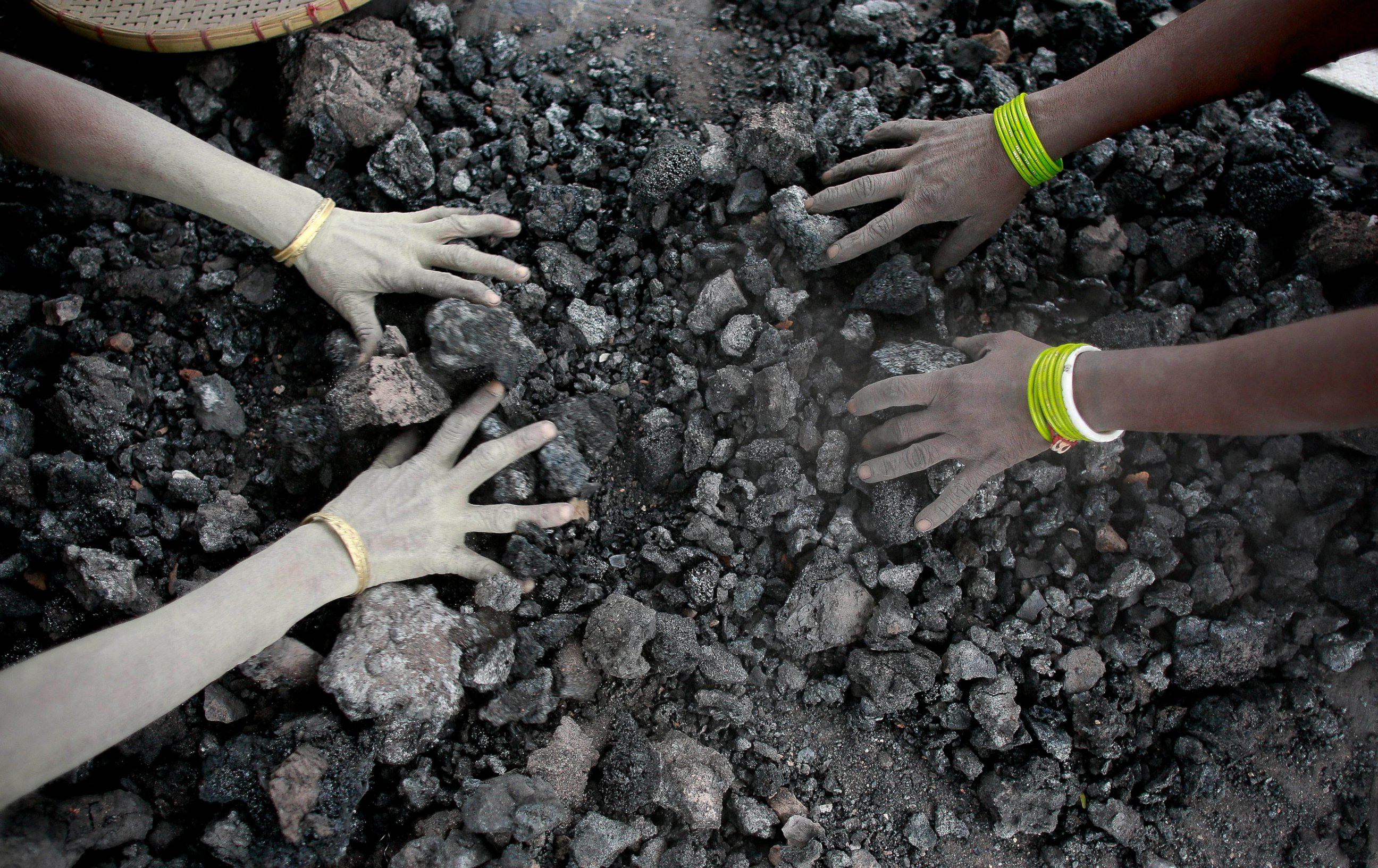 PHOTO: In this Monday, Dec. 14, 2015, file photo, Indian women use bare hands to pick reusable pieces from heaps of used coal discarded by a carbon factory in Gauhati, India.