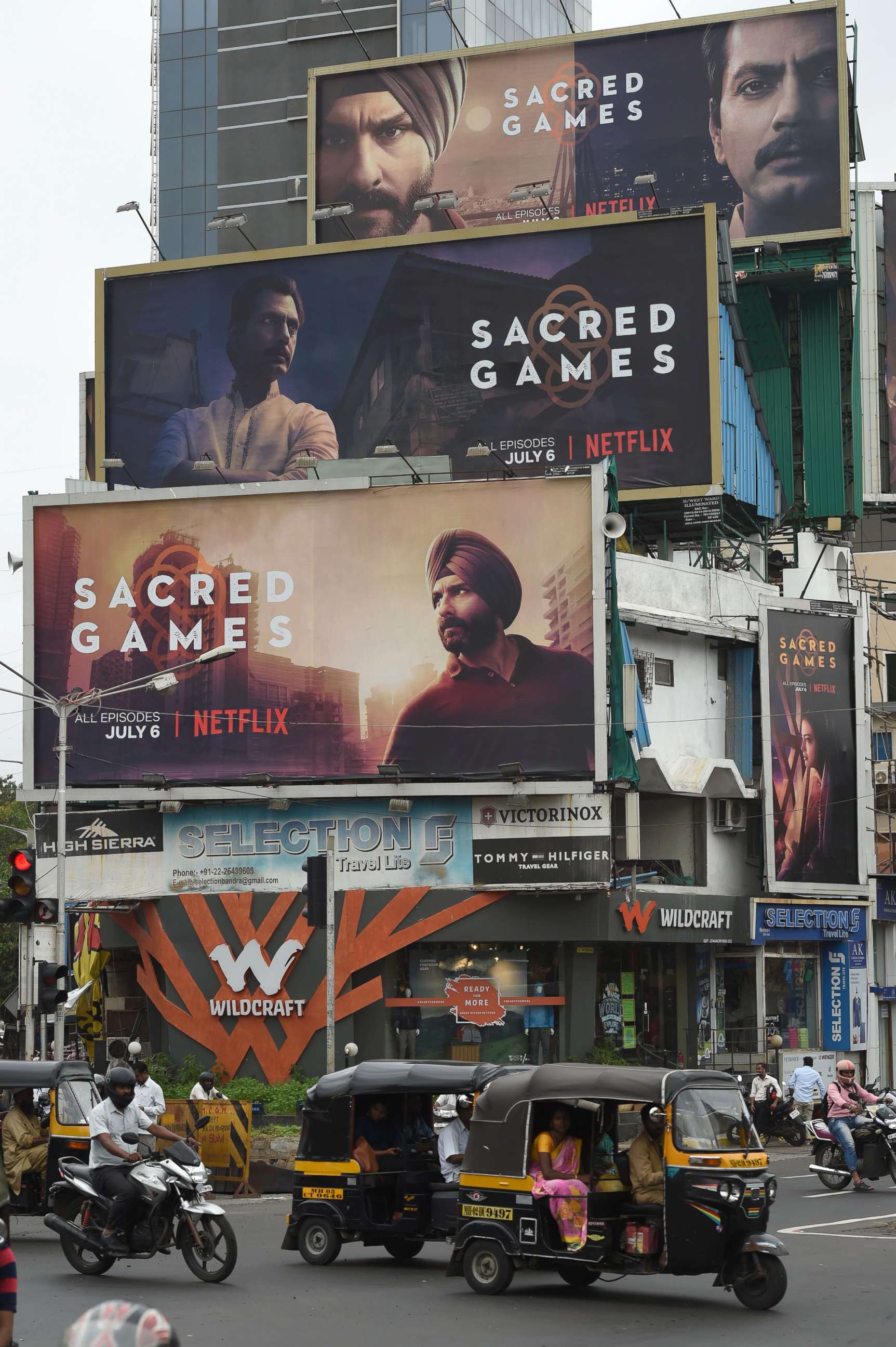 PHOTO: Indian commuters travel past large billboards for "Sacred Games", the upcoming Indian series on Netflix, in Mumbai in this July 4, 2018 file photo.