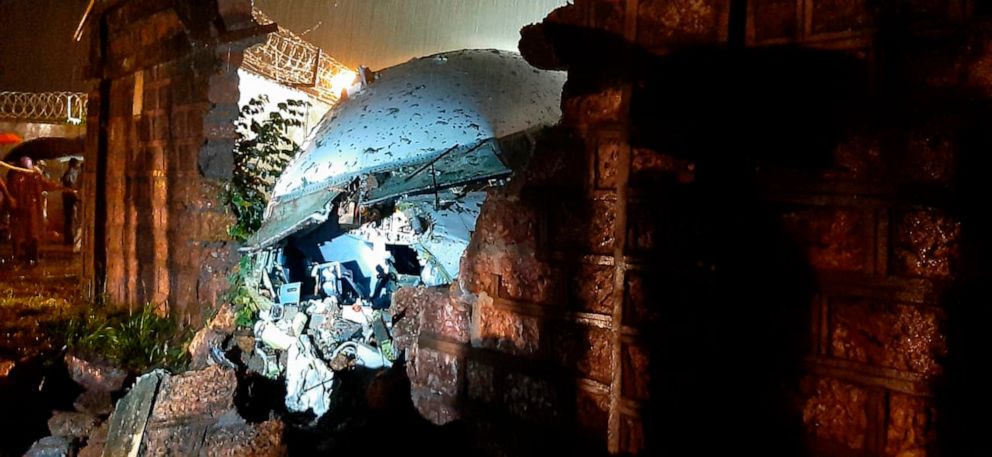 PHOTO: A part of the Air India Express flight is seen through a broken wall after it skidded off a runway while landing at the airport in Kozhikode, Kerala state, India, Aug. 7, 2020.