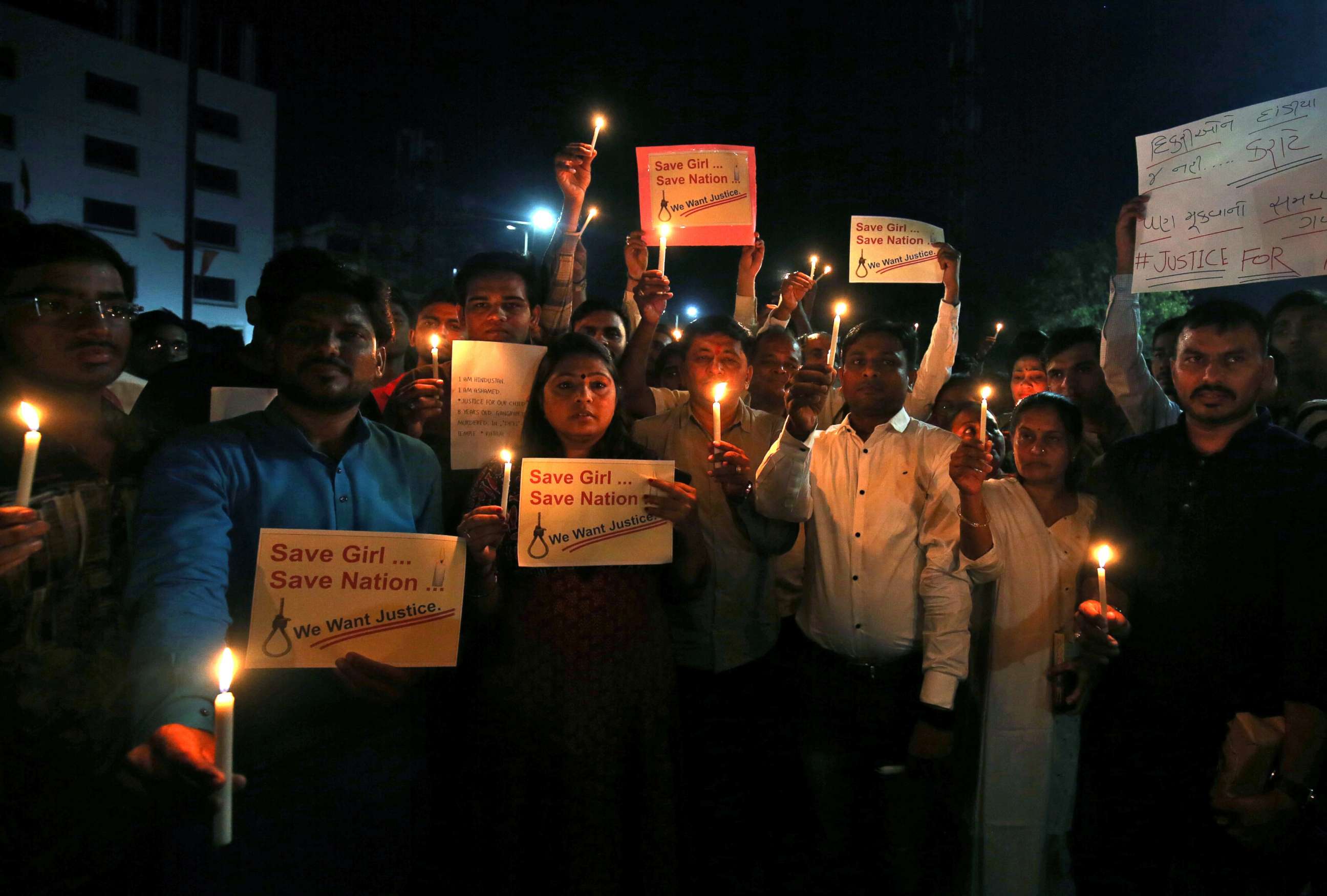 PHOTO: People hold candles and placards during a vigil as they protest against the rapes in Ahmedabad, India, April 15, 2018. 