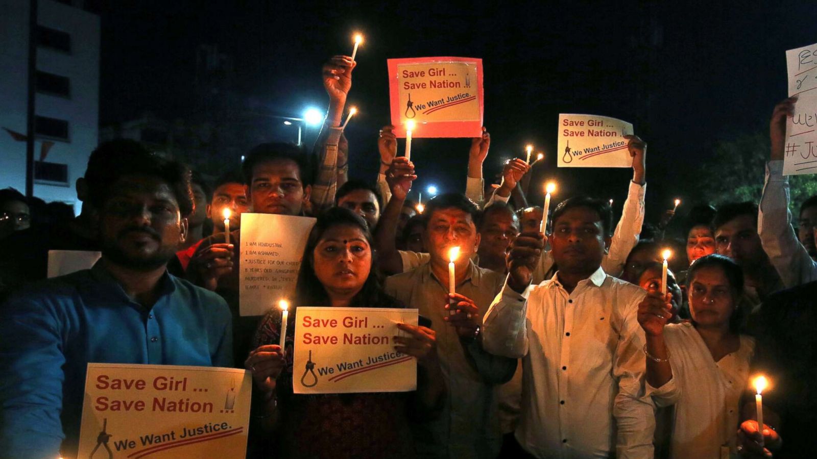 PHOTO: People hold candles and placards during a vigil as they protest against the rapes in Ahmedabad, India, April 15, 2018.