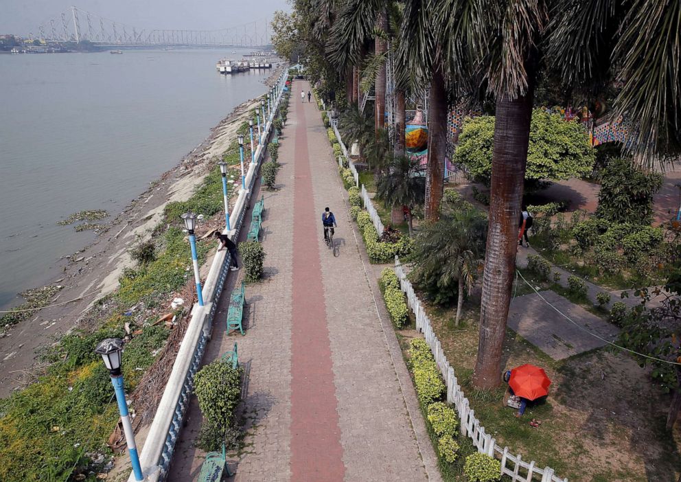 PHOTO: A man rides his cycle in an empty park along the banks of the river Ganges after the government tightened up measures for coronavirus prevention, in Kolkata, India, March 17, 2020. 