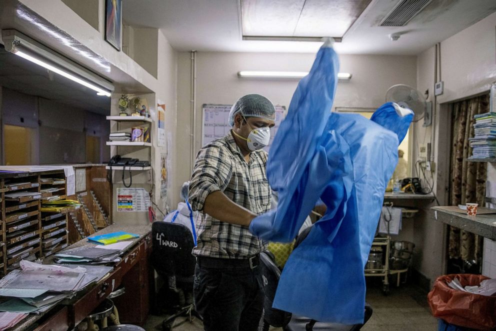 PHOTO: Rohan Aggarwal, a resident doctor treating patients suffering from the coronavirus disease, puts on personal protective equipment (PPE) before treating patients during his 27-hour shift at Holy Family Hospital in New Delhi, India, May 2, 2021.