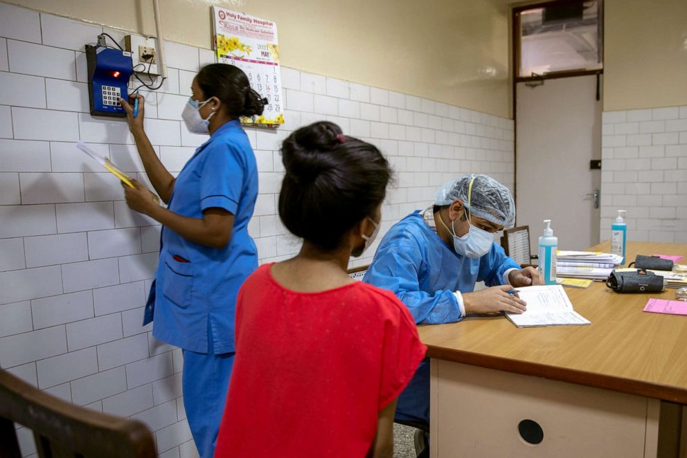 PHOTO: Rohan Aggarwal, 26, a resident doctor treating patients suffering from the coronavirus disease (COVID-19), talks to a COVID-19 patient during his 27-hour shift at Holy Family Hospital in New Delhi, India, May 1, 2021.