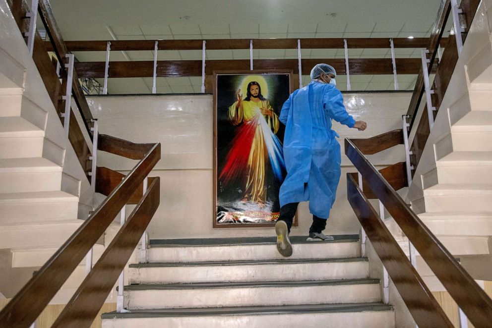 PHOTO: Rohan Aggarwal, a resident doctor treating patients suffering from the coronavirus disease (COVID-19), rushes to an emergency call at a ward for COVID-19 patients, during his 27-hour shift at Holy Family Hospital in New Delhi, India, May 1, 2021.