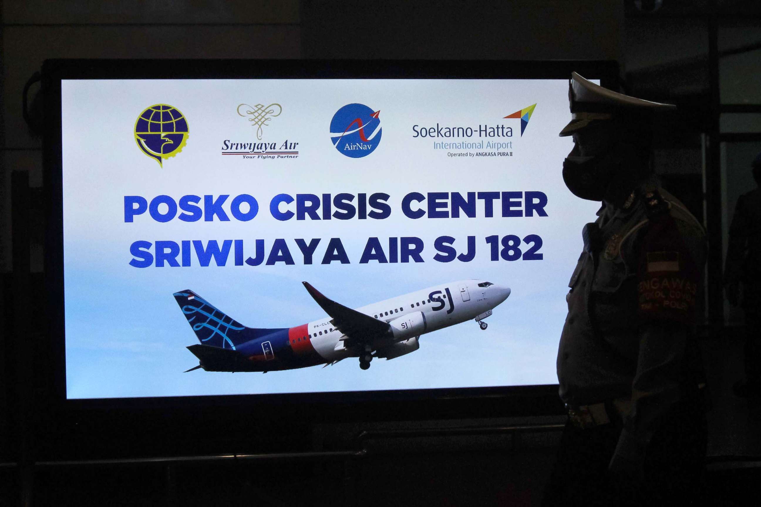 PHOTO: A security personnel stands in front of a sign for a crisis centre for Sriwijaya Air flight SJY182 at the Soekarno-Hatta international airport in Tangerang near Jakarta , Jan. 9, 2021.