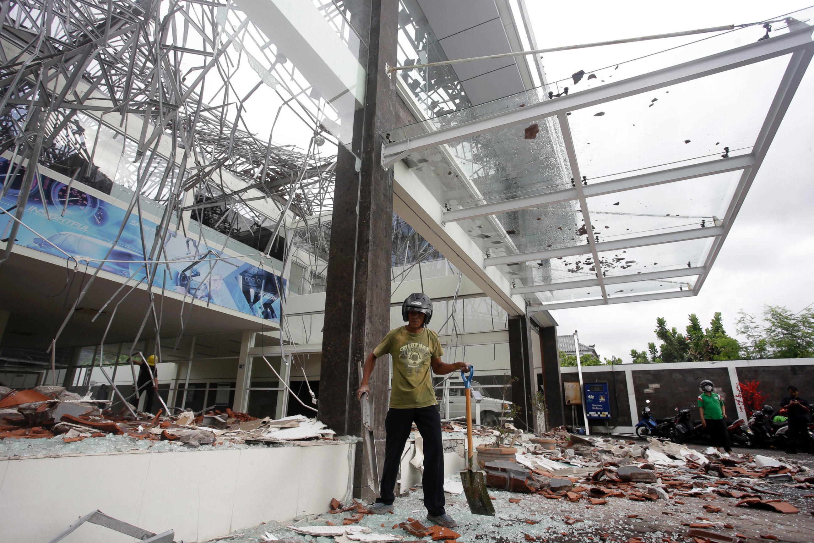 A man cleans up at a building damaged by an earthquake in Bali, Indonesia, Monday, Aug. 6, 2018.