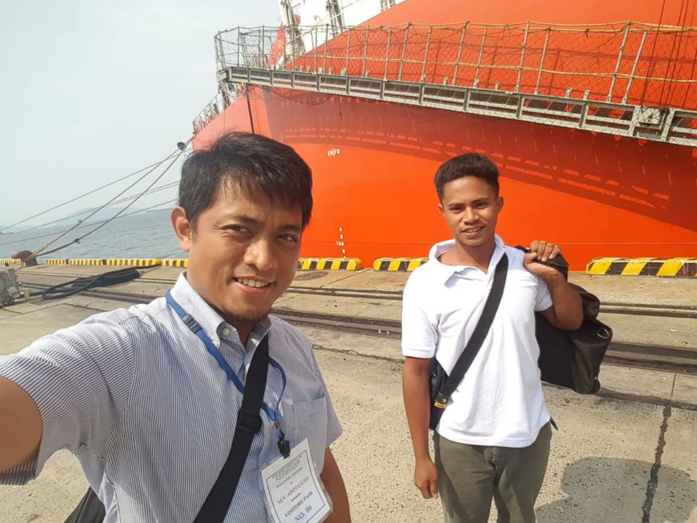 PHOTO: In this undated photo released by Indonesian Consulate General in Osaka, 18-year-old Aldi Novel Adilang, right, is pictured in front of Panamanian-flagged vessel, MV Arpeggio after being rescued in the waters near Guam.
