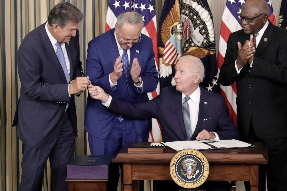 PHOTO: President Joe Biden gives Sen. Joe Manchin the pen he used to sign The Inflation Reduction Act with Senate Majority Leader Charles Schumer and House Majority Whip James Clyburn in the State Dining Room of the White House Aug. 16, 2022.