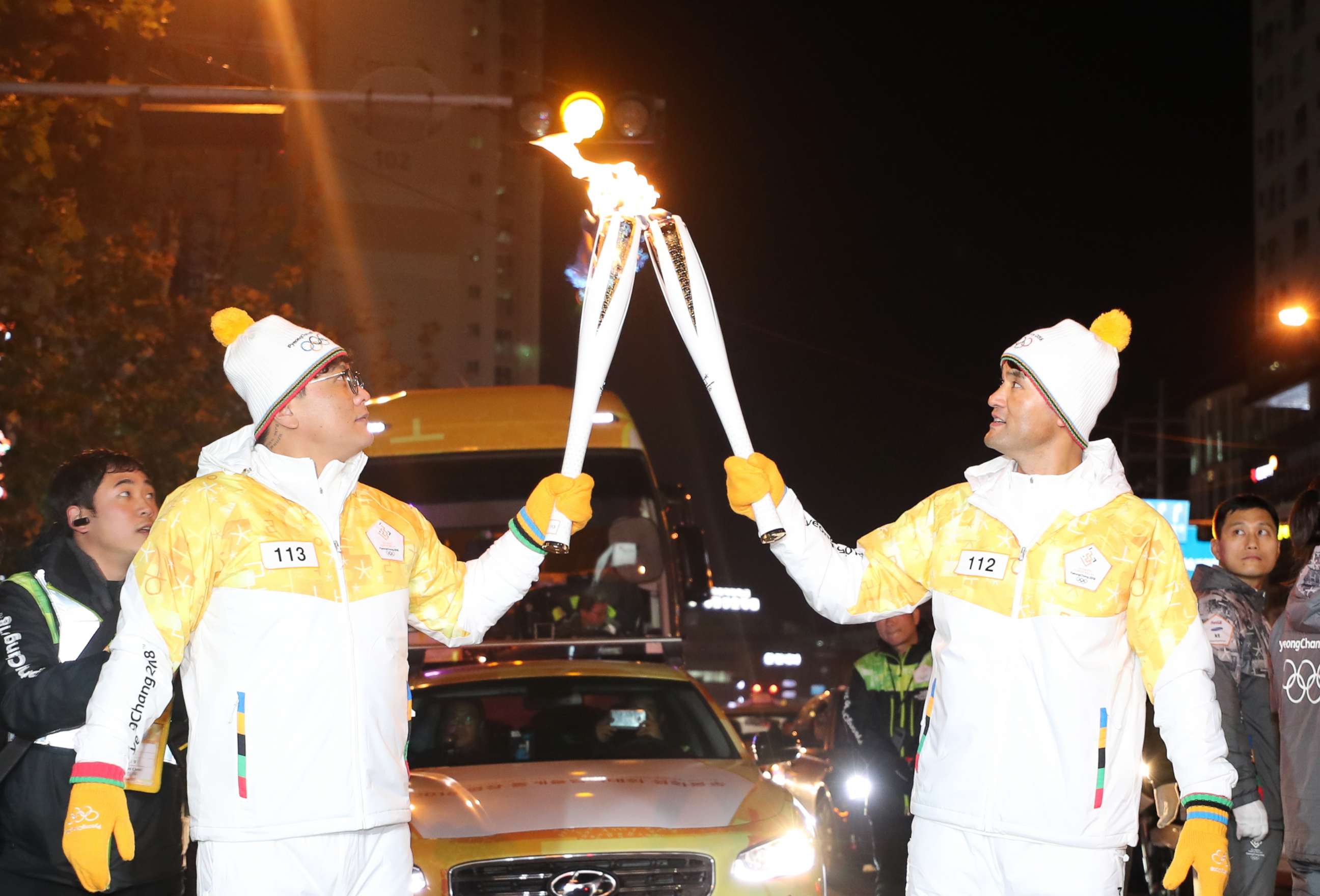 PHOTO: Retired major league pitcher Park Chan-ho, right, delivers the Olympic flame for the 2018 PyeongChang Games to Hanwha Eagles slugger Kim Tae-gyun at an event in Daejeon on Dec. 9, 2017, as part of the Olympic torch relay.