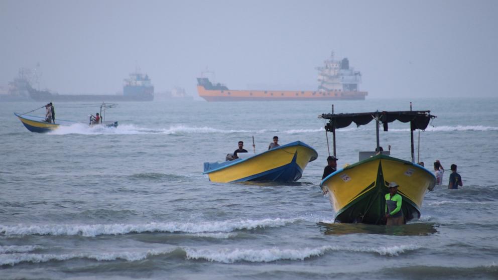 PHOTO: Small boats line the shore as cargo ships and other commercial vessels appear anchored in the Strait of Hormuz off Bandar Abbas, Iran, July 27, 2026. 