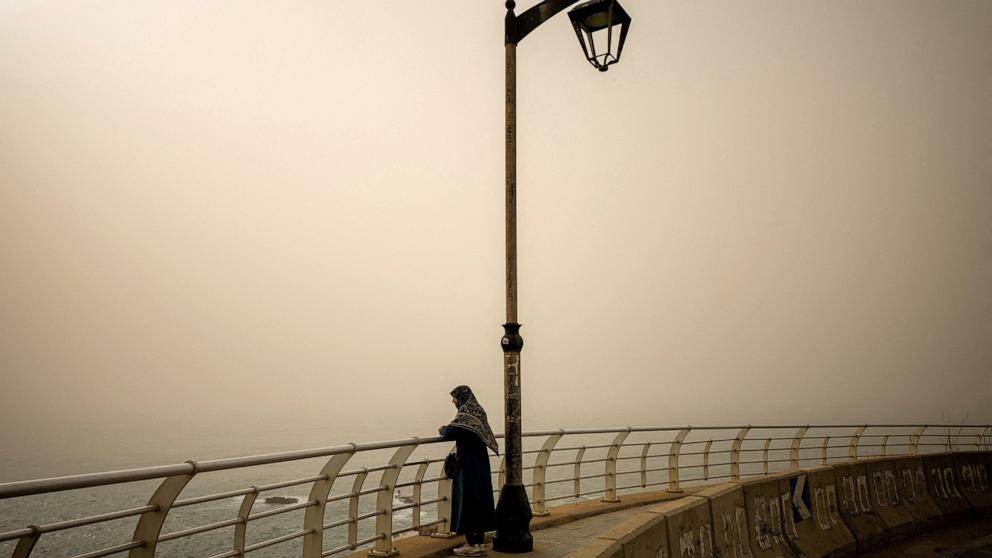 PHOTO: A woman looks at the sea as dust covers the city, amid escalating hostilities between Israel and Hezbollah, as the U.S.-Israel conflict with Iran continues, in Beirut, Lebanon, April 3, 2026. 