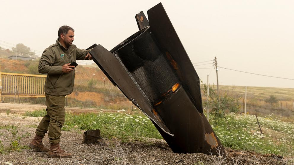 PHOTO: An Israeli soldier looks at a tail section of a ballistic missile from Iran, that is sticked out of the ground near a cowshed in a Jewish settlement in the northern Jordan Valley, April 3, 2026 in Jordan Valley, West Bank.