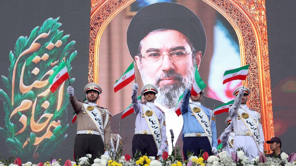 PHOTO: Iran Army members wave national flags as they stand in front of a poster of Iranian Supreme Leader Ayatollah Mojtaba Khamenei during a rally in Tehran, Iran, April 29, 2026. 