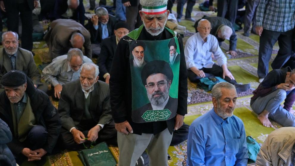 PHOTO: An Iranian worshipper holds a portrait of the Supreme Leader Ayatollah Mojtaba Khamenei, late Supreme Leader Ayatollah Ali Khamenei and the late Ayatollah Khomeini, during Friday prayers at the Tehran University, April 24, 2026.
