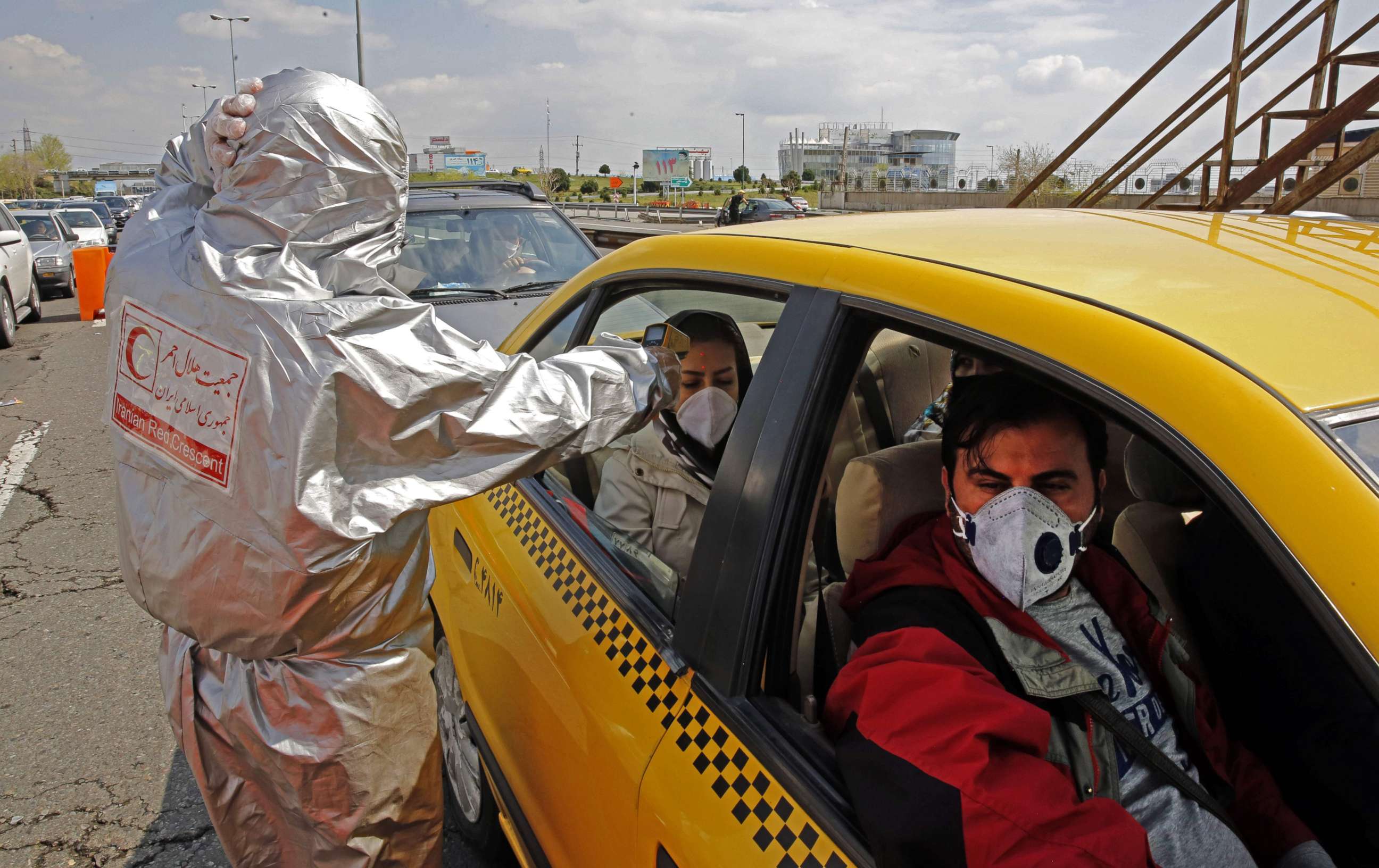 PHOTO: Members of Iranian Red Crescent test people with possible coronavirus COVID-19 symptoms, as police blocked Tehran to Alborz highway to check every car following ordered by the Iranian government, outside Tehran on March 26, 2020. 