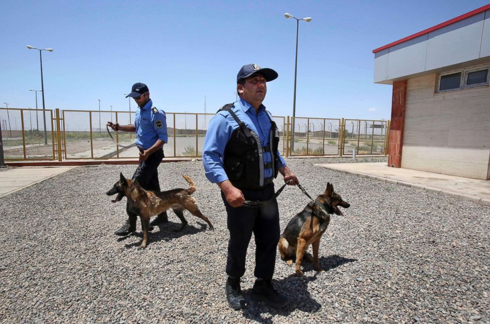 PHOTO: Two Iranian custom officers hold their drug-sniffing dogs at Iran's Dogharoun custom's house on border with Afghanistan, near Taibad in eastern Iran, June 1, 2014.