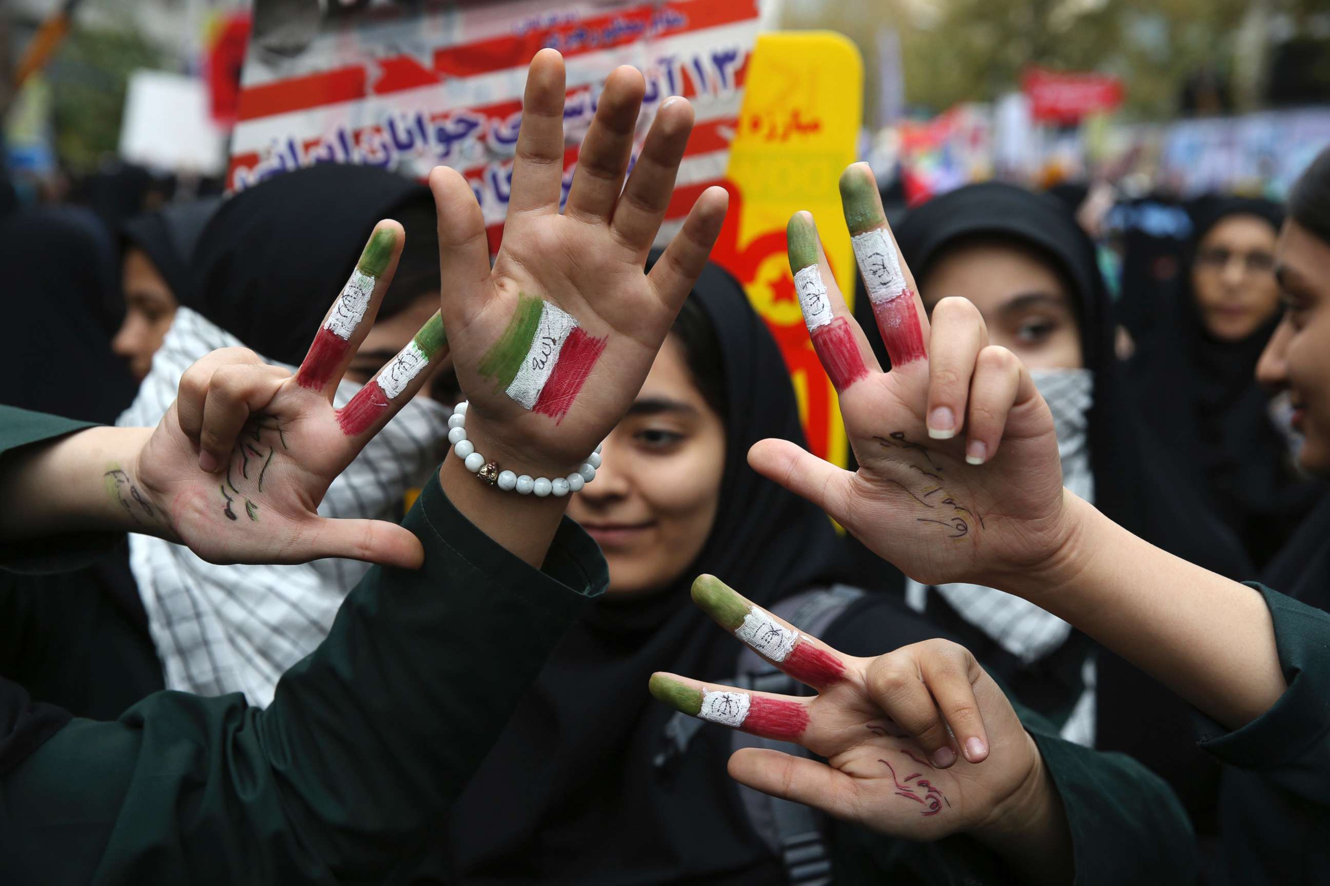 PHOTO: Iranian schoolgirls hold up their hands painted with the colors of their country's flag and writing in Persian which reads, "Death to America," in Tehran, Iran, Nov. 4, 2017. 