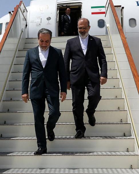 This handout picture provided by the Iranian Foreign Ministry on May 11, 2025, shows Iran's Foreign Minister Abbas Araghchi (L) descending the stairs of an aircraft upon his arrival in Muscat.