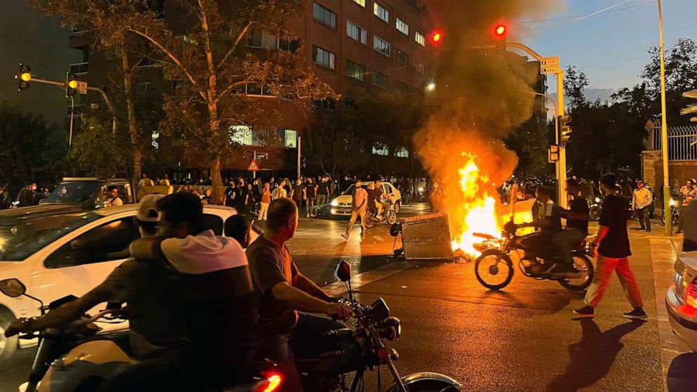 PHOTO: FILE - Demonstrators gathering around a burning barricade during a protest for Mahsa Amini, a woman who died after being arrested by the Islamic republic's "morality police", in Tehran, Sept. 19, 2022.