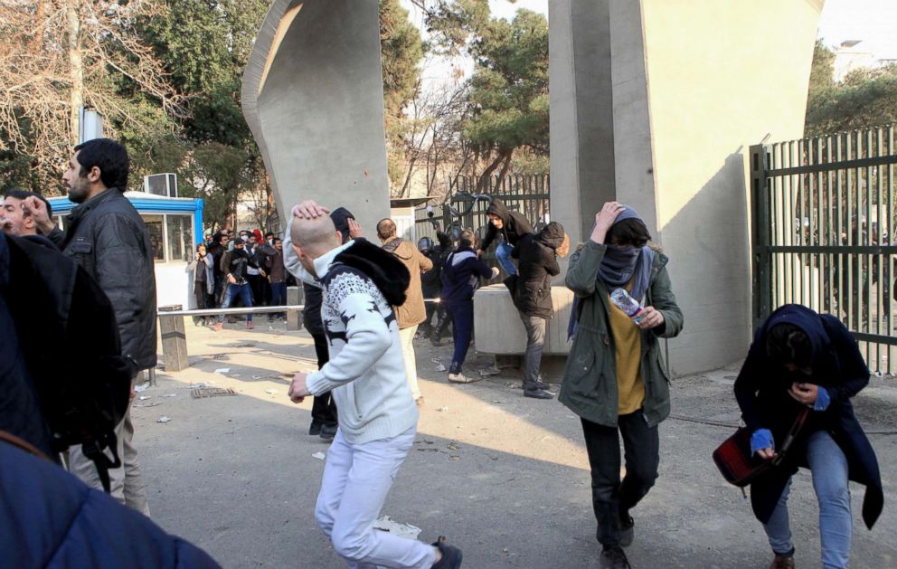 PHOTO: Iranian students run for cover from tear gas at the University of Tehran during a demonstration driven by anger over economic problems, in the capital Tehran, Dec. 30, 2017. 