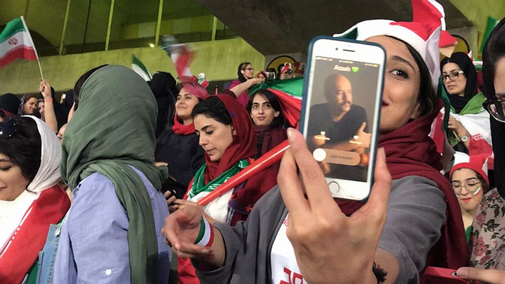 PHOTO: Zahra Ahooei receives a phone call from her husband during half time while attending a soccer game in Tehran, Iran, Oct. 10, 2019. They could not sit besides each other because men and women sections are segregated.