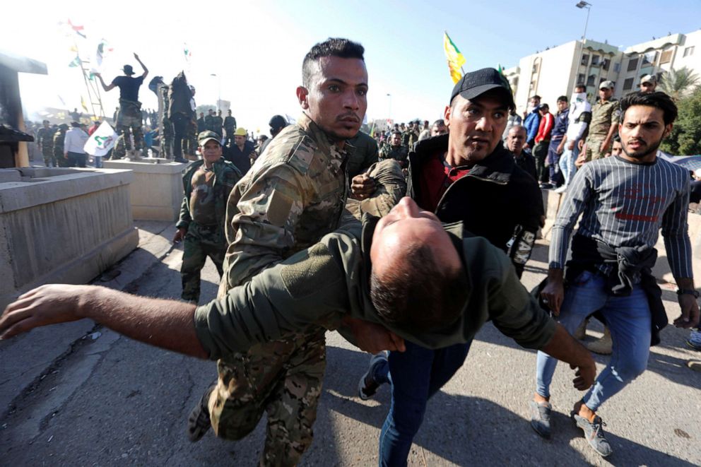 PHOTO: A wounded member of Hashd al-Shaabi (paramilitary forces) gets help during a protest to condemn air strikes on their bases, outside the main gate of the U.S. Embassy in Baghdad, Dec. 31, 2019.