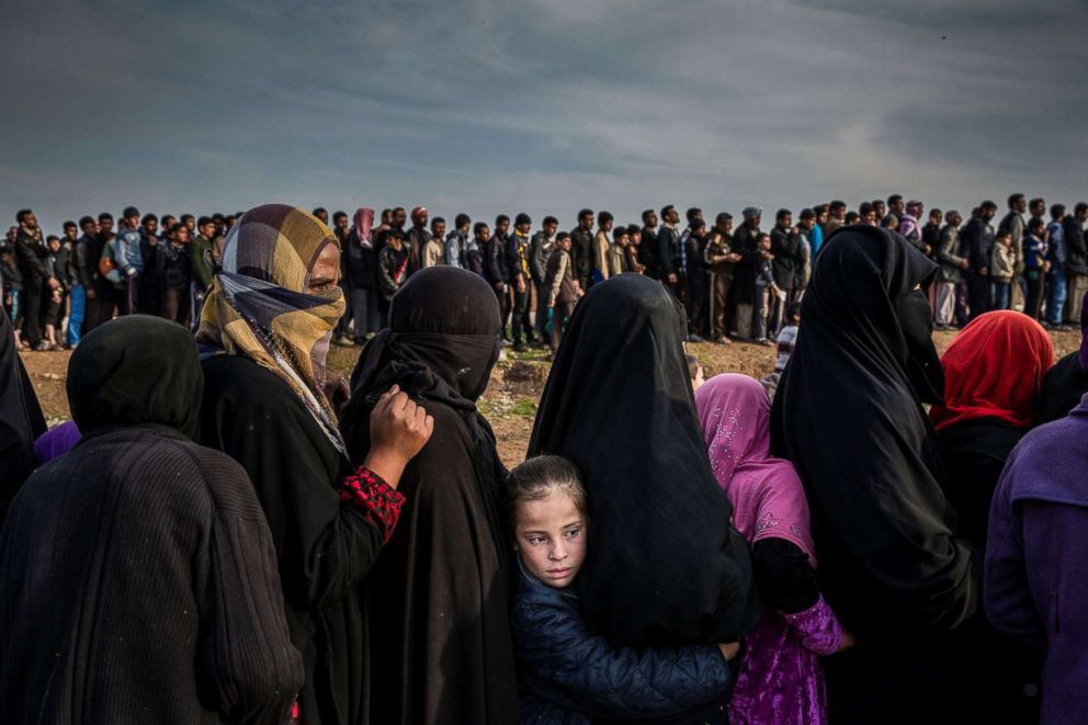 PHOTO: Civilians who had remained in west Mosul during the battle to retake the city, lined up for an aid distribution in the Mamun neighborhood in Iraq July 2017.    