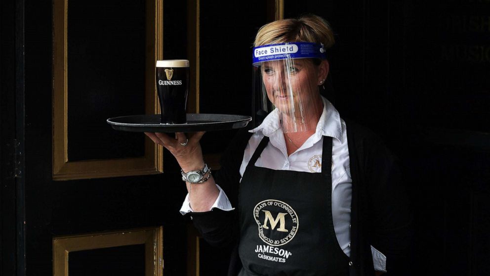 PHOTO: A woman waits for a pint of Guinness to settle before serving a customer at Murrays pub, June 29, 2020, in Dublin, Ireland.