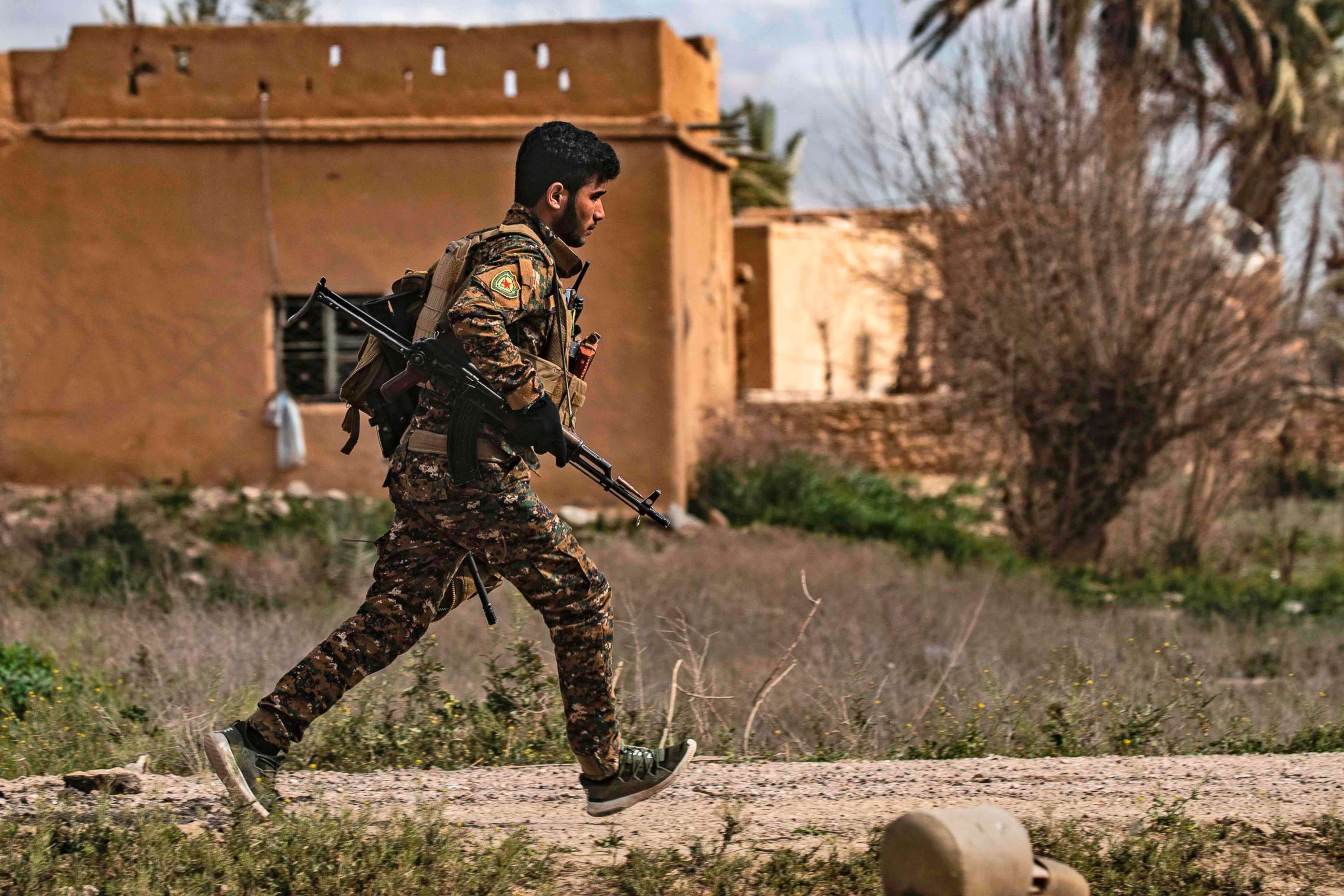 PHOTO: A member of the Syrian Democratic Forces (SDF) runs for cover during shelling on the Islamic State group's last holdout of Baghouz, in the eastern Syrian Deir Ezzor province, March 3, 2019.