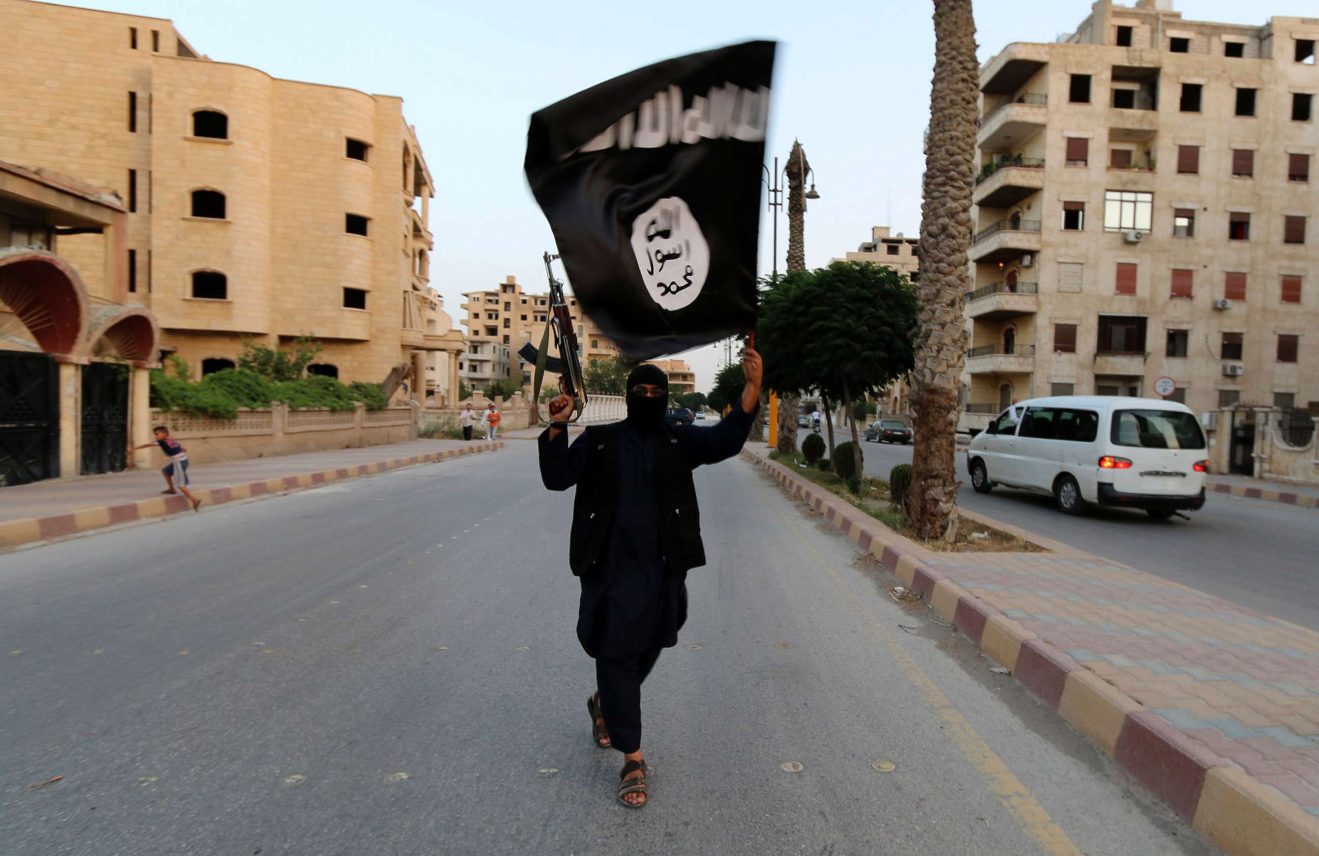PHOTO: In this file photo, a member loyal to the Islamic State in Iraq and the Levant (ISIL) waves an ISIL flag in Raqqa, Syria, June 29, 2014. 