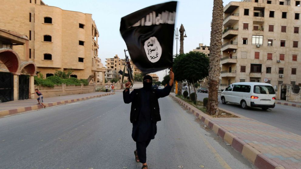 In this file photo, a member loyal to the Islamic State in Iraq and the Levant (ISIL) waves an ISIL flag in Raqqa, Syria, June 29, 2014. 