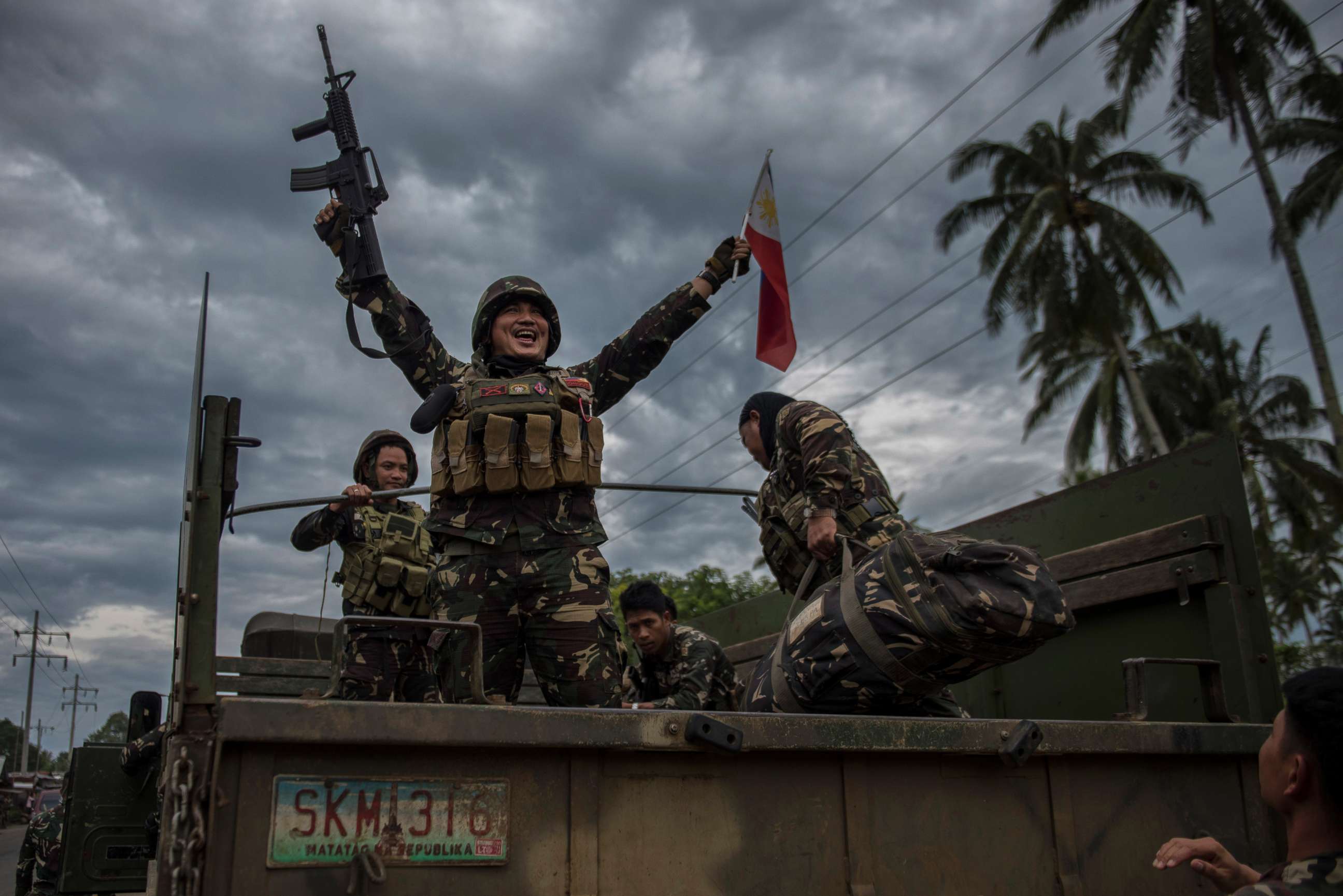 PHOTO: A government soldier waving the Philippine flag as they get ready to leave the battle against IS-inspired militants, Oct. 20, 2017, in Saguiaran town in Lanao del Sur, southern Philippines. 